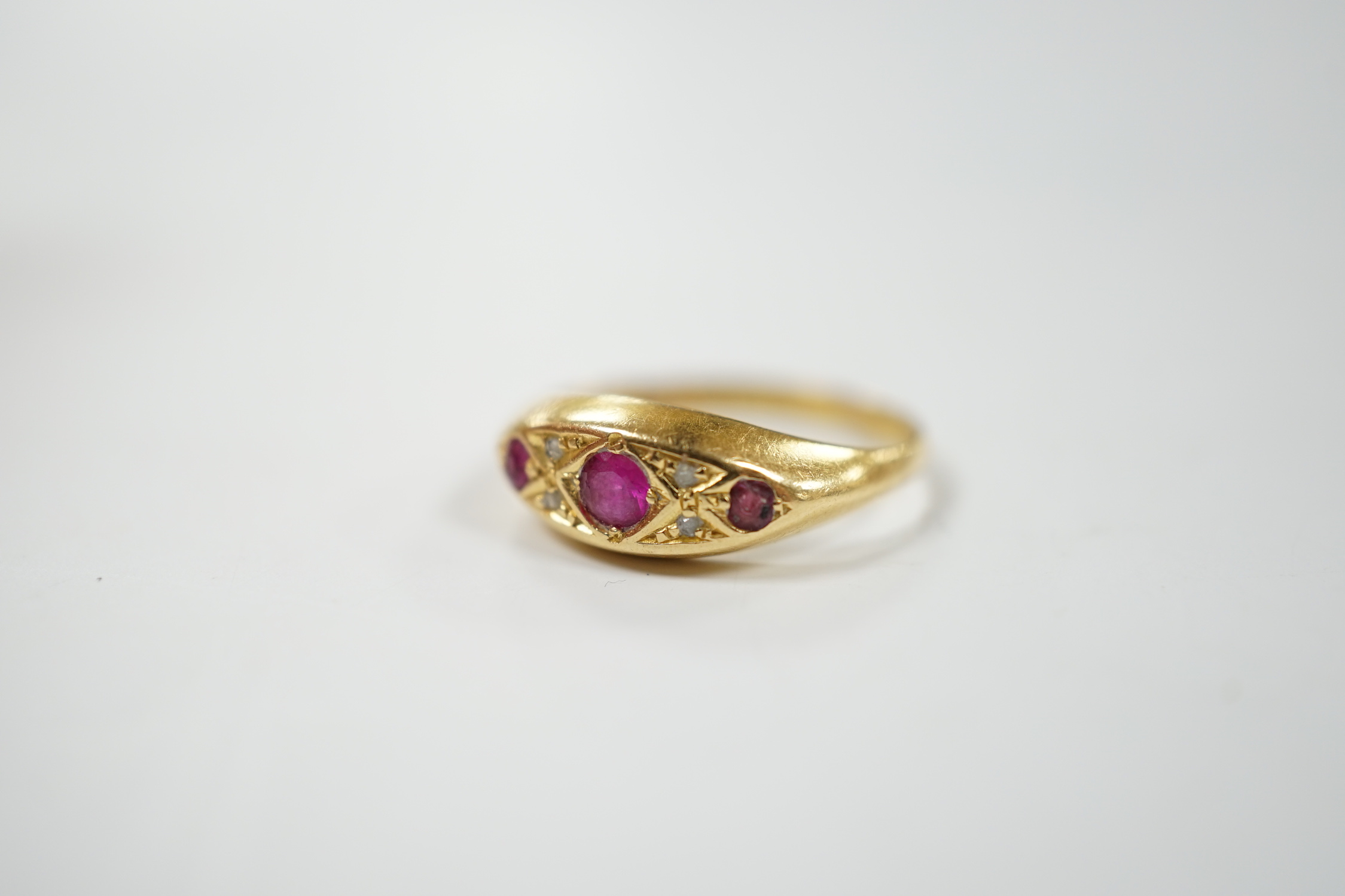 A George V 18ct gold, three stone ruby and four stone diamond chip set ring, size K, gross weight 2.4 grams.